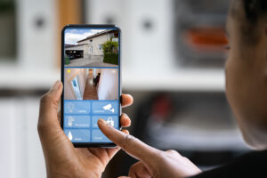 Person using a smartphone app to manage home security cameras, locks, and sensors.